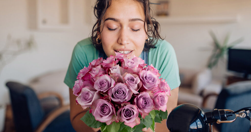 Portrait Of A Beautiful Woman Enjoying The Smell Of Fresh Flowers