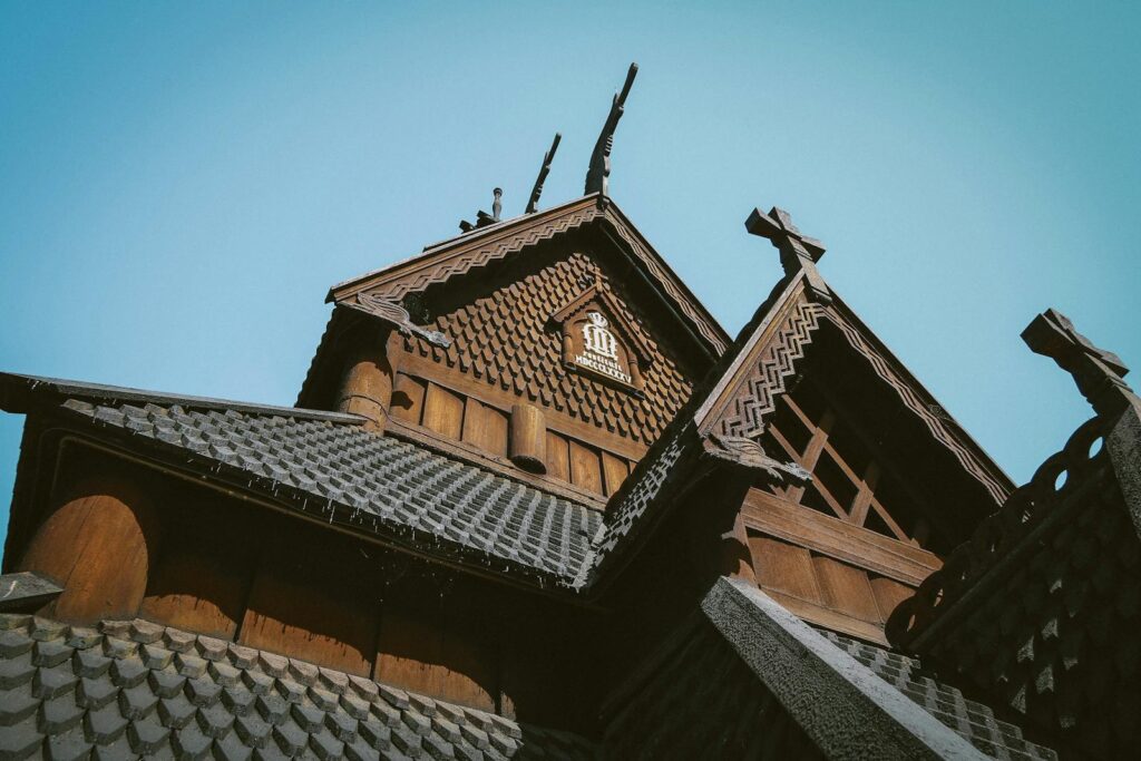 Low angle view of a traditional wooden building with intricate roof patterns under a clear sky.