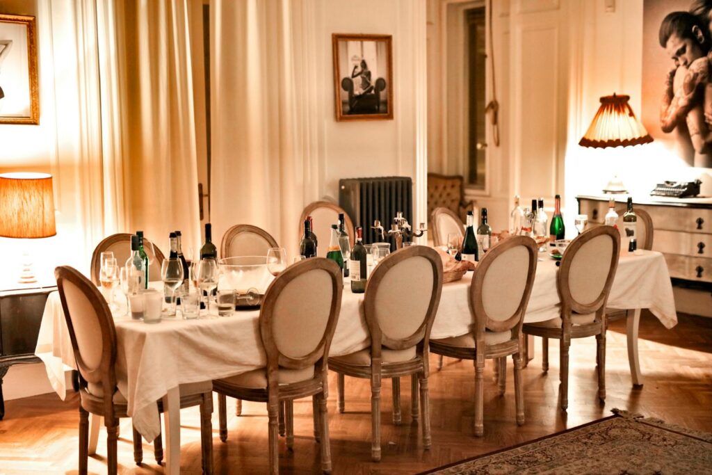 Luxurious dining room setup with bottles and glasses after a dinner party.