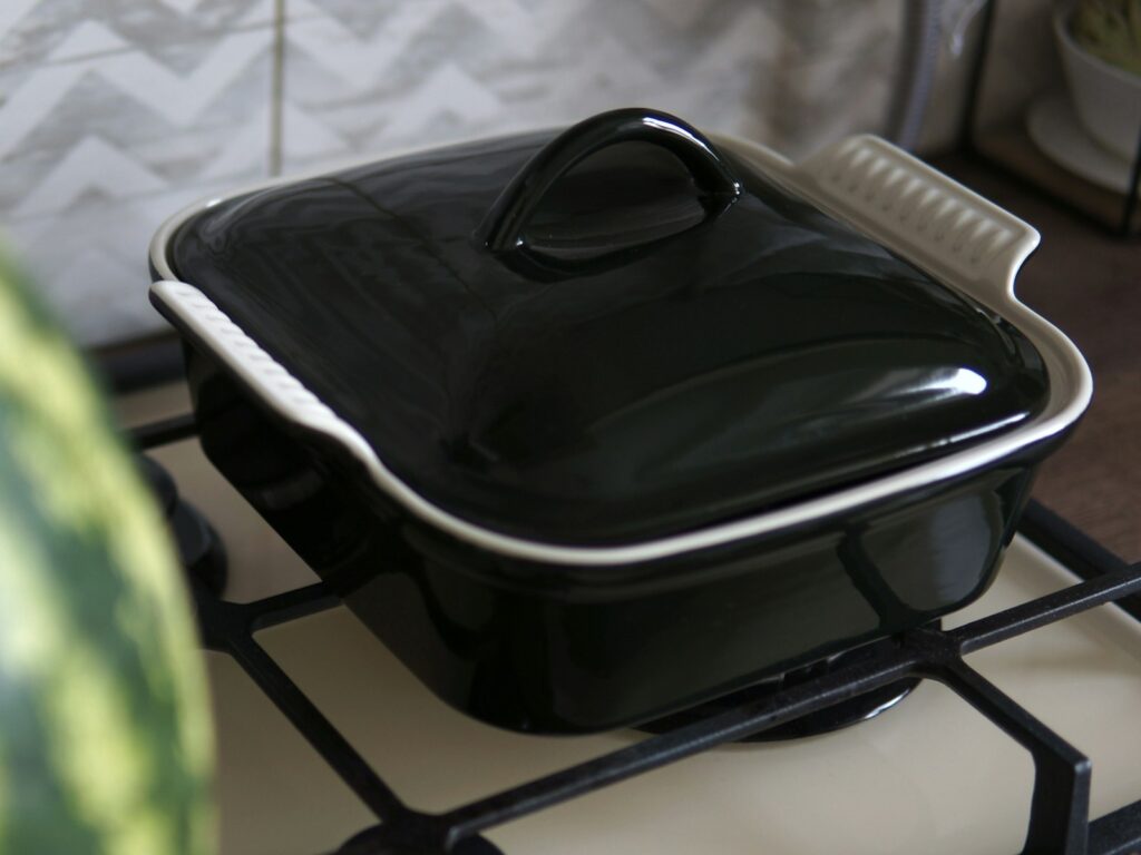 A black casserole dish sitting on top of a stove