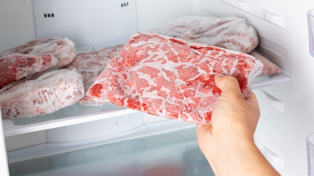 The,man,takes,out,a,bag,of,frozen,meat,from