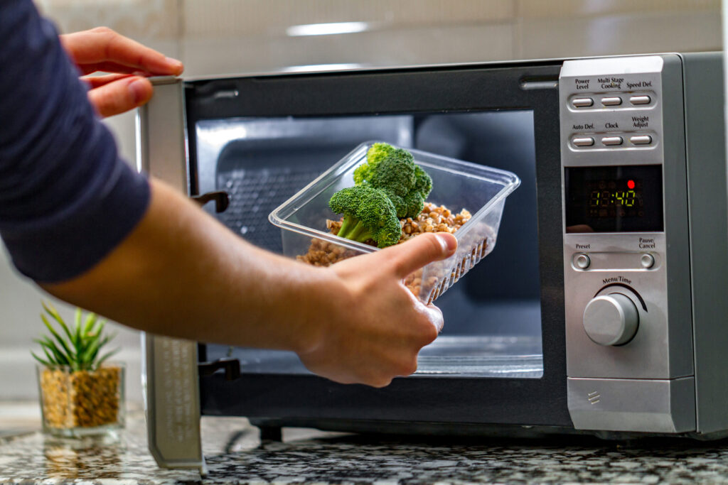Person Putting Food Into Microwave Scaled