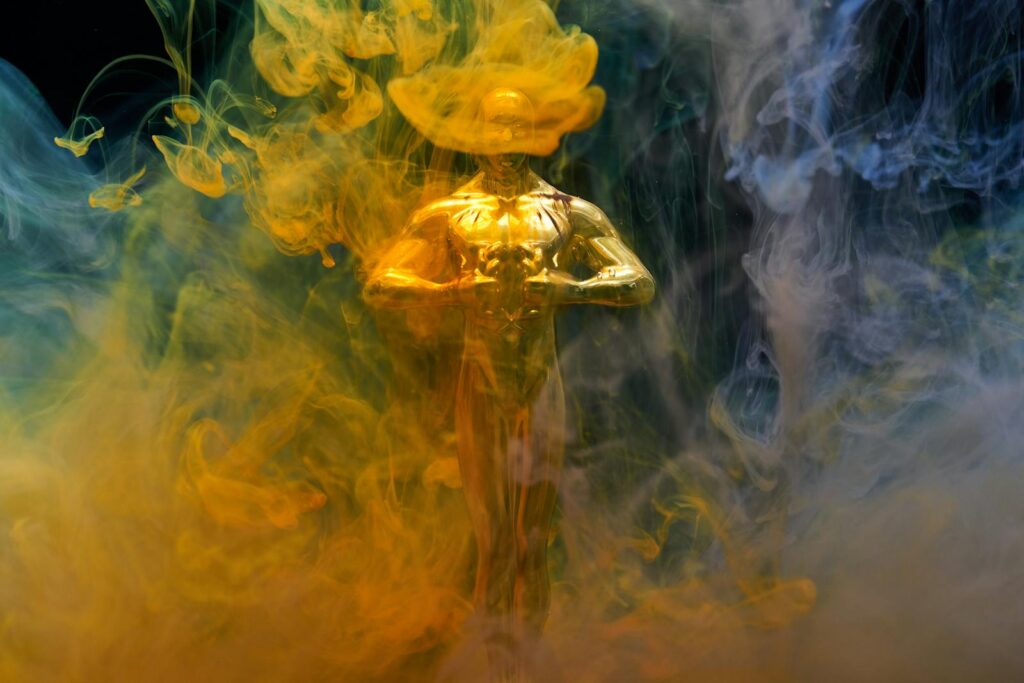 A golden statuette enveloped in vibrant yellow and blue smoke, symbolizing achievement and success.