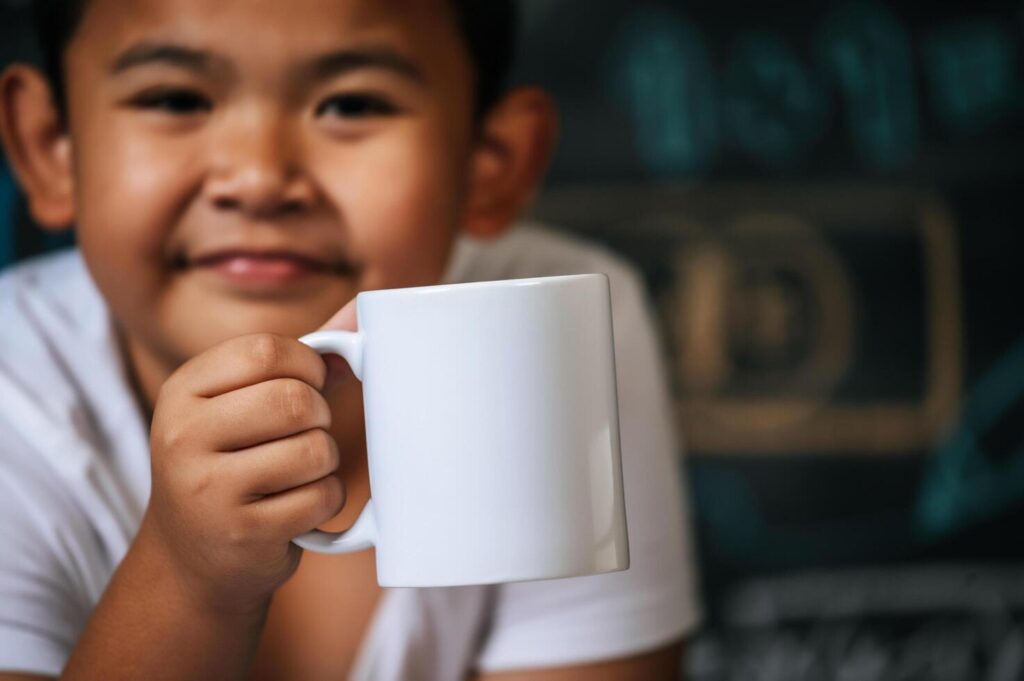 Child Sitting And Holding Cup In The Classroom Free Photo