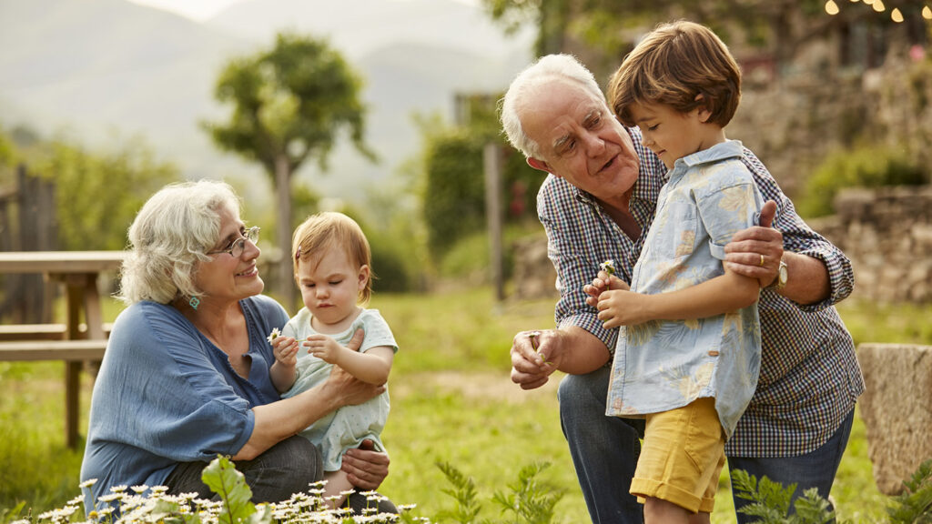 Grandparents Talking To Children In Yard