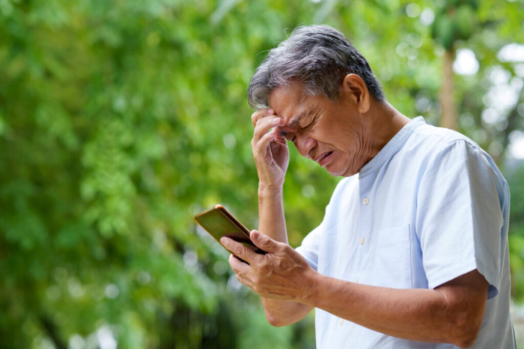 Sad Senior Man Using Smartphone.
