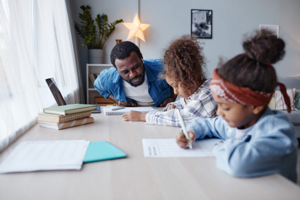 Portrait Of Caring Father Doing Homework With Two Little Girls At Home Copy Space Stockpack Adobe Stock 1200x800