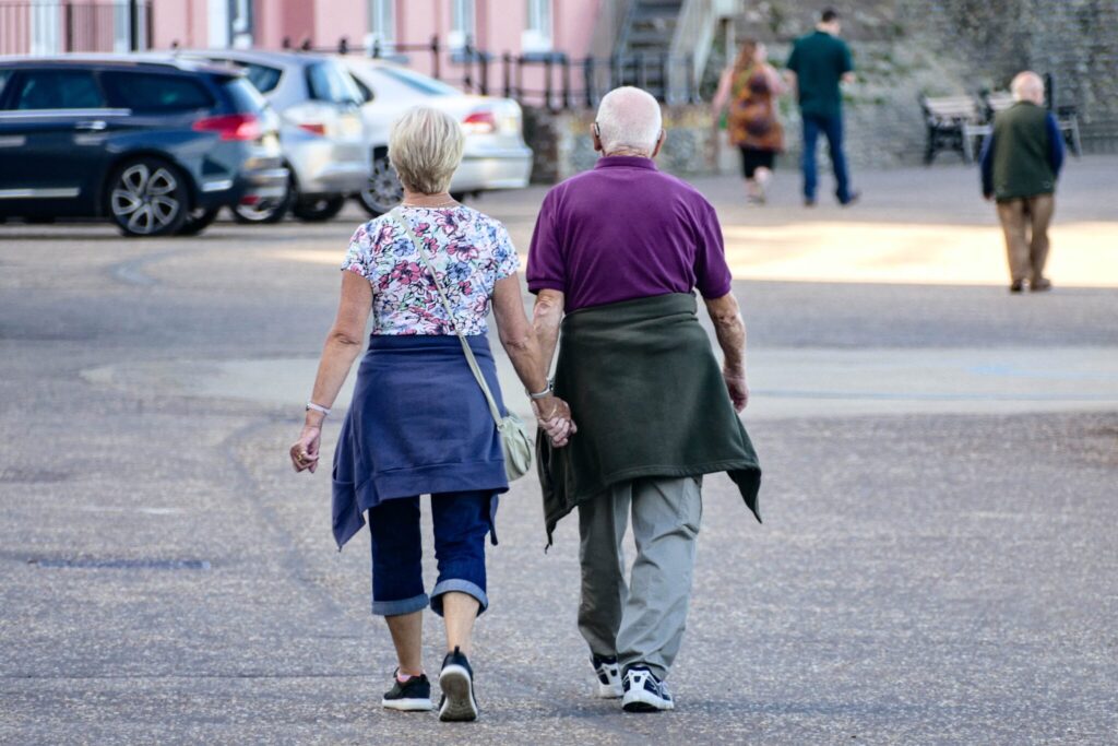 Retired Couple Holding Hands Scaled