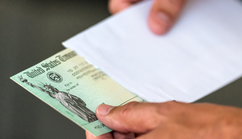 Closeup Of A Hand Removing A Us Government Treasury Check From A