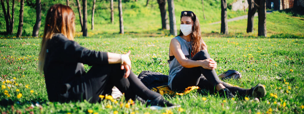Two Girls With Masks In The Park During Pandemic