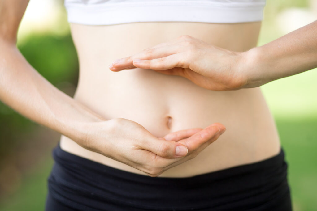 Close Up Of Young Womans Hands And Slim Belly