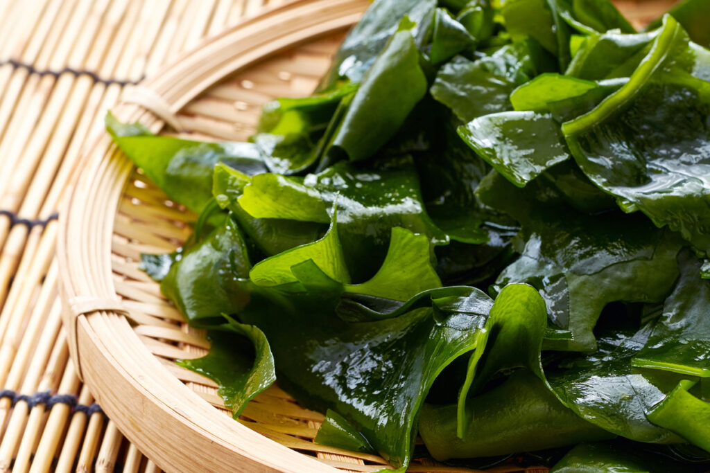 Laminaria Or Kelp Seaweed In Wood Plate On Wood Table Background. Fresh Laminaria Or Kelp Seaweed Background. Konbu, Alga