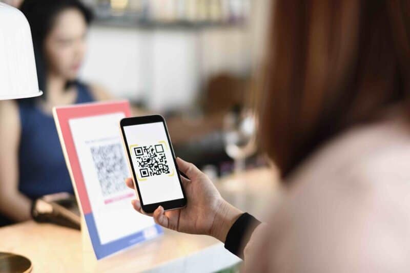 Woman Making A Qr Code Payment In A Bar