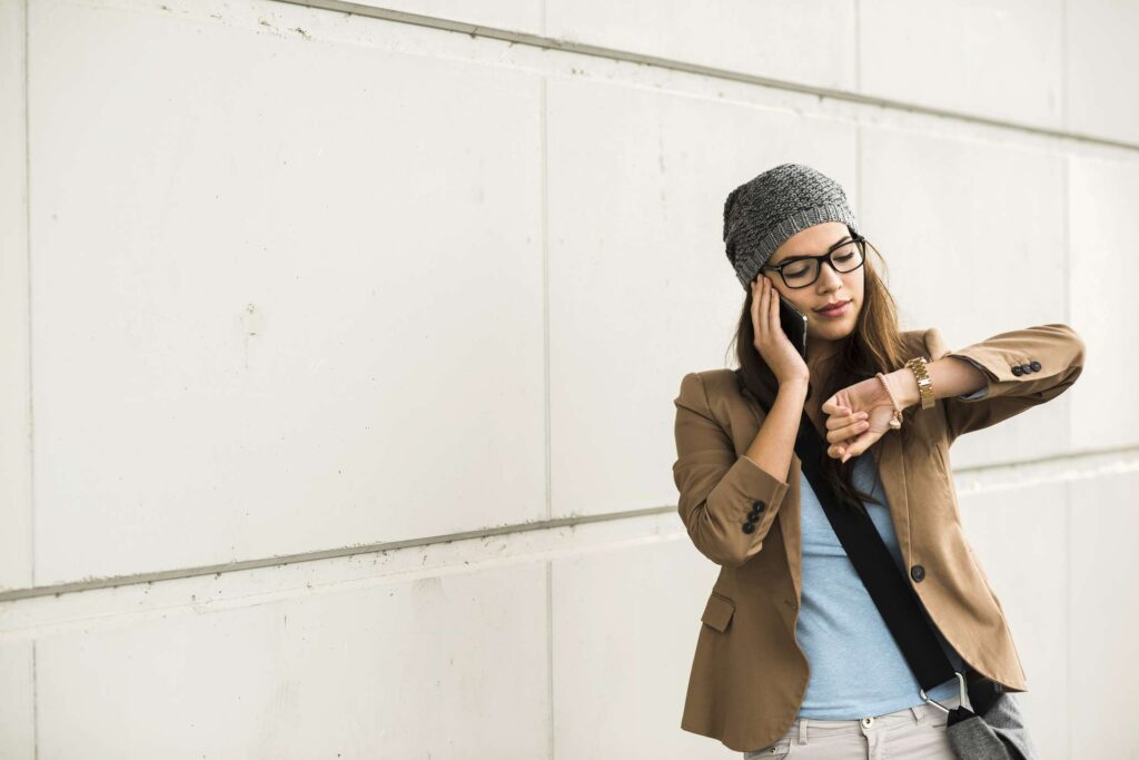 Young Woman Telephoning With Smartphone While Checking Time 545881393 5a05e298e258f800379bed83