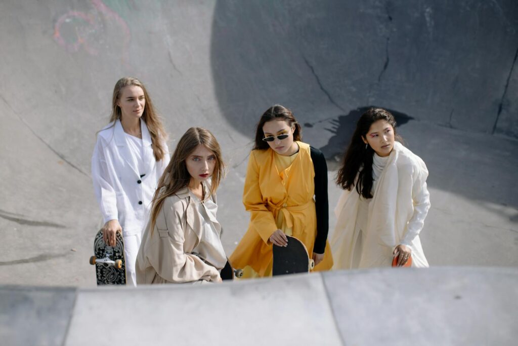 Fashionable group of women skateboarding in a modern urban skate park setting.