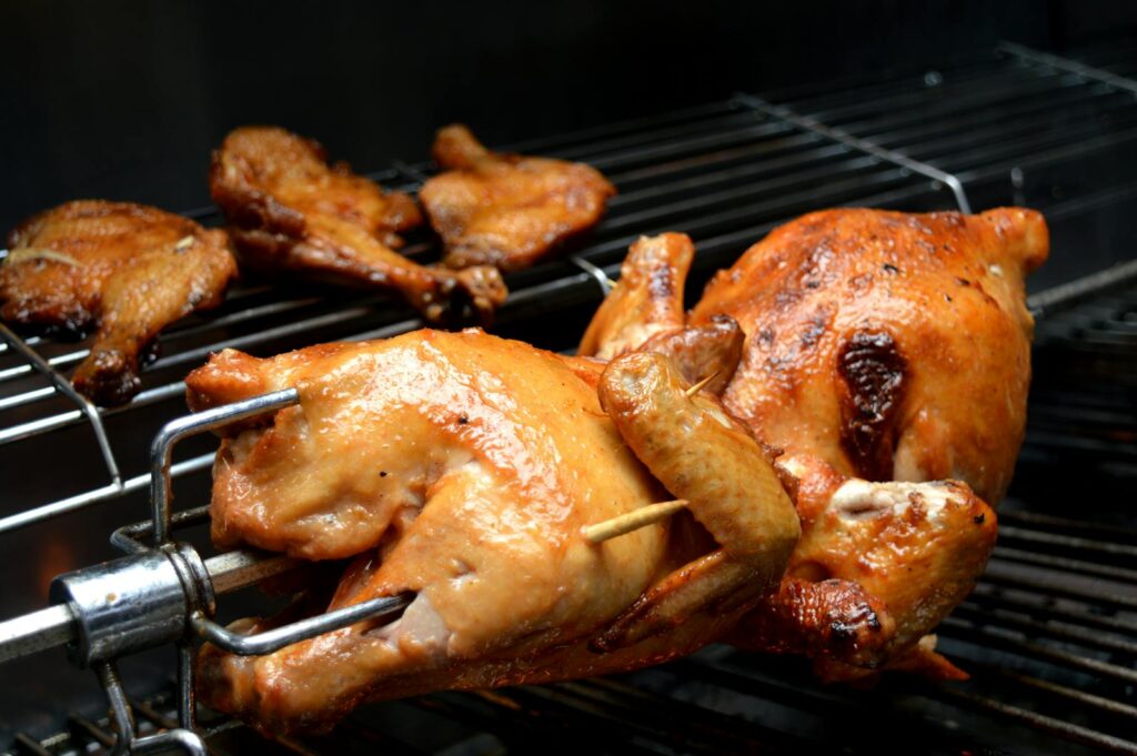 Juicy roasted chicken cooked on a grill, showcasing mouthwatering food photography.