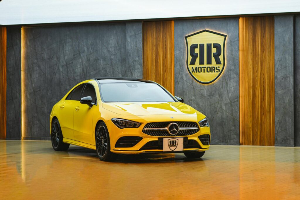 Stunning yellow Mercedes-Benz car on display in a modern showroom, showcasing luxury aesthetics.