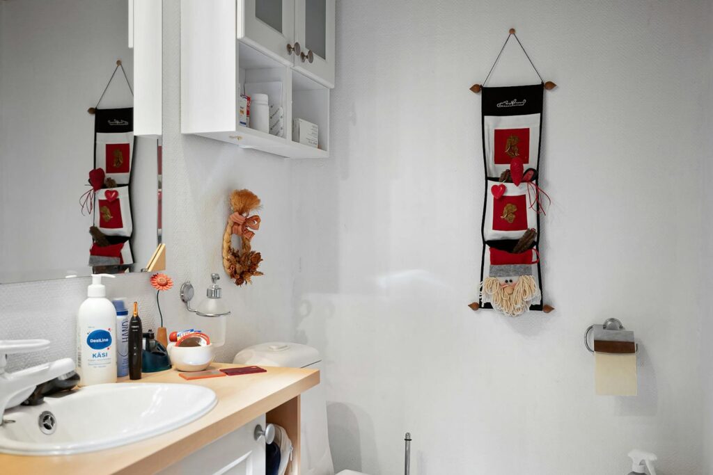 A modern, minimalist bathroom featuring Scandinavian-style decor and a functional white vanity.