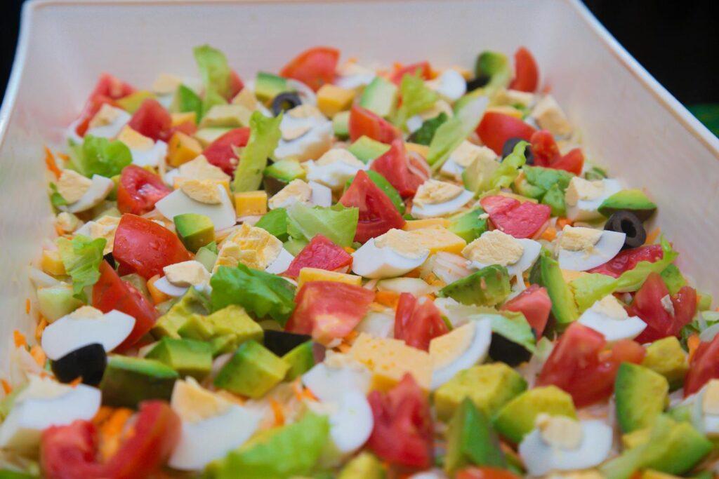 Vibrant salad of avocados, eggs, and tomatoes in a bowl, ideal for healthy eating.