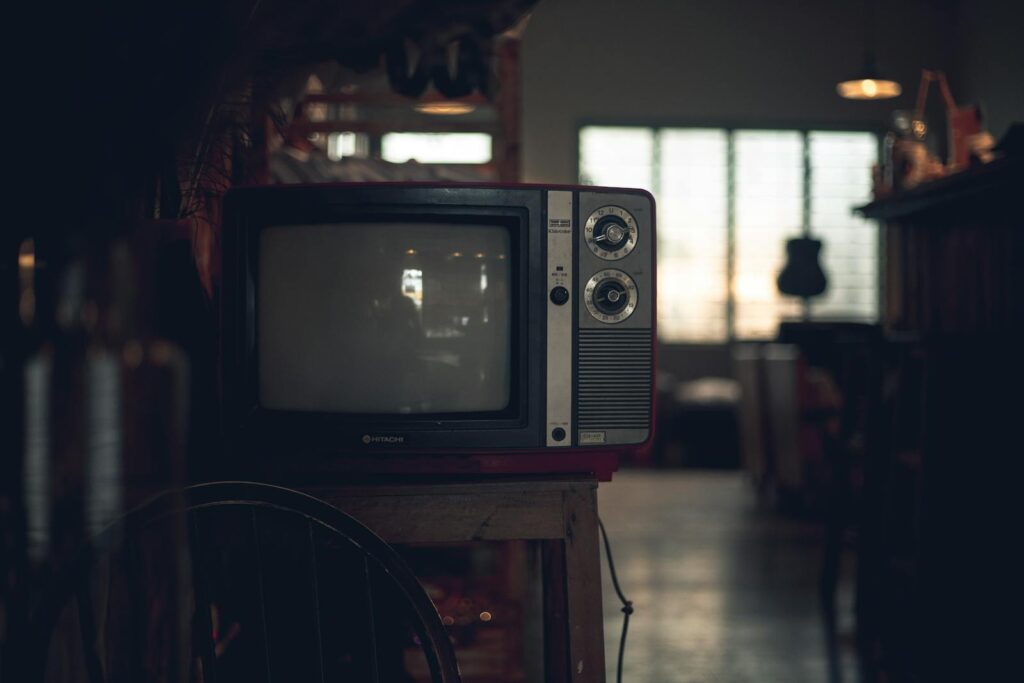 A classic CRT television in a dimly lit vintage room in Ho Chi Minh City, Vietnam.