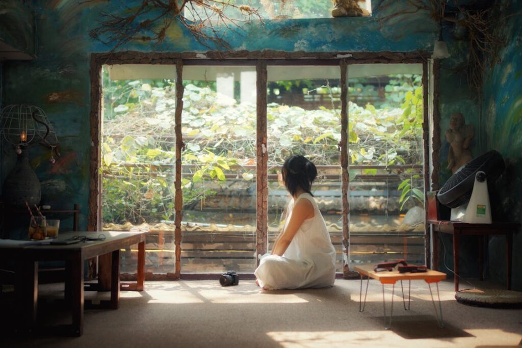 A serene figure sits cross legged in a sunlit room, embodying tranquility through deep meditation and mindfulness