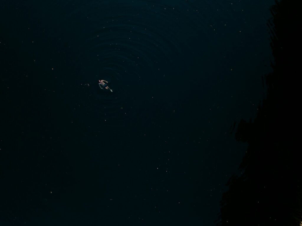 a person floating in a body of water at night