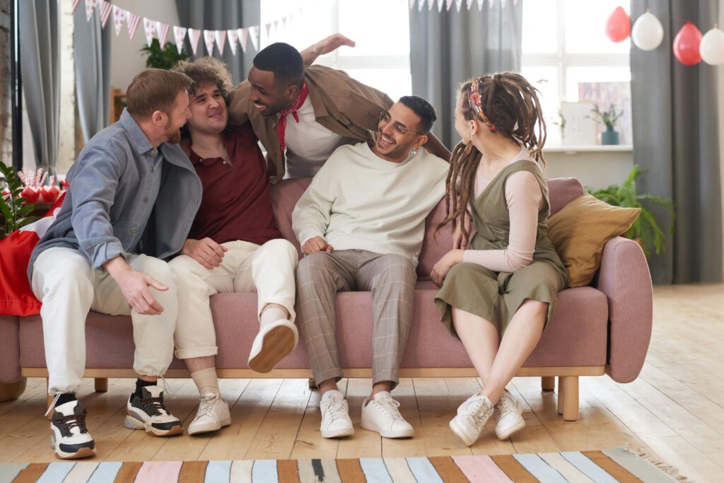 Group of friends laughing together on a cozy couch