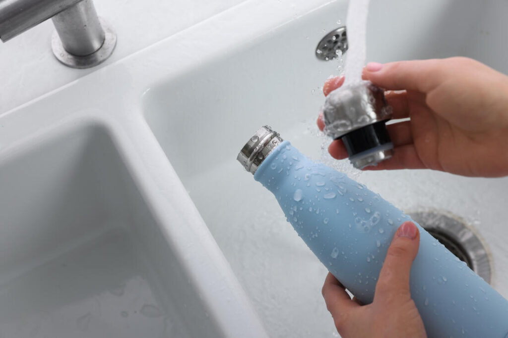 Woman Washing Thermo Bottle In Kitchen, Above View