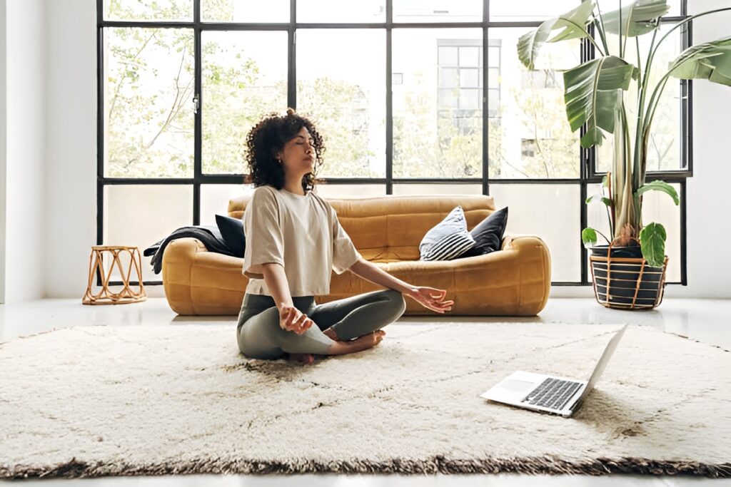 Serene individual meditates in a sunlit room, surrounded by digital devices