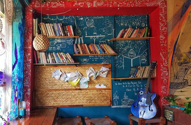 Colorful room with bookshelves, guitar, and artistic decorations creating a cozy atmosphere.