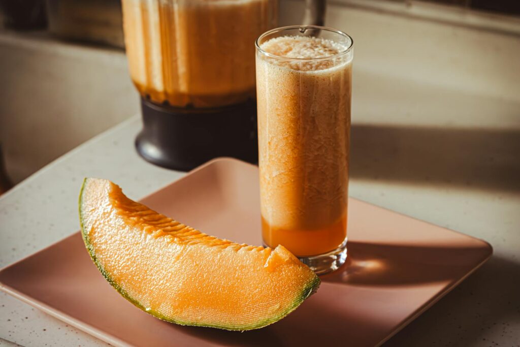 Delicious cantaloupe smoothie with a fresh melon slice, perfect for a healthy snack.