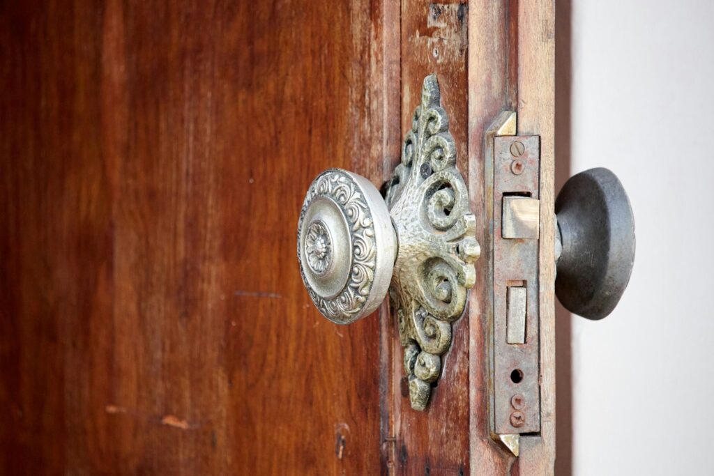 A close up of a door handle on a wooden door