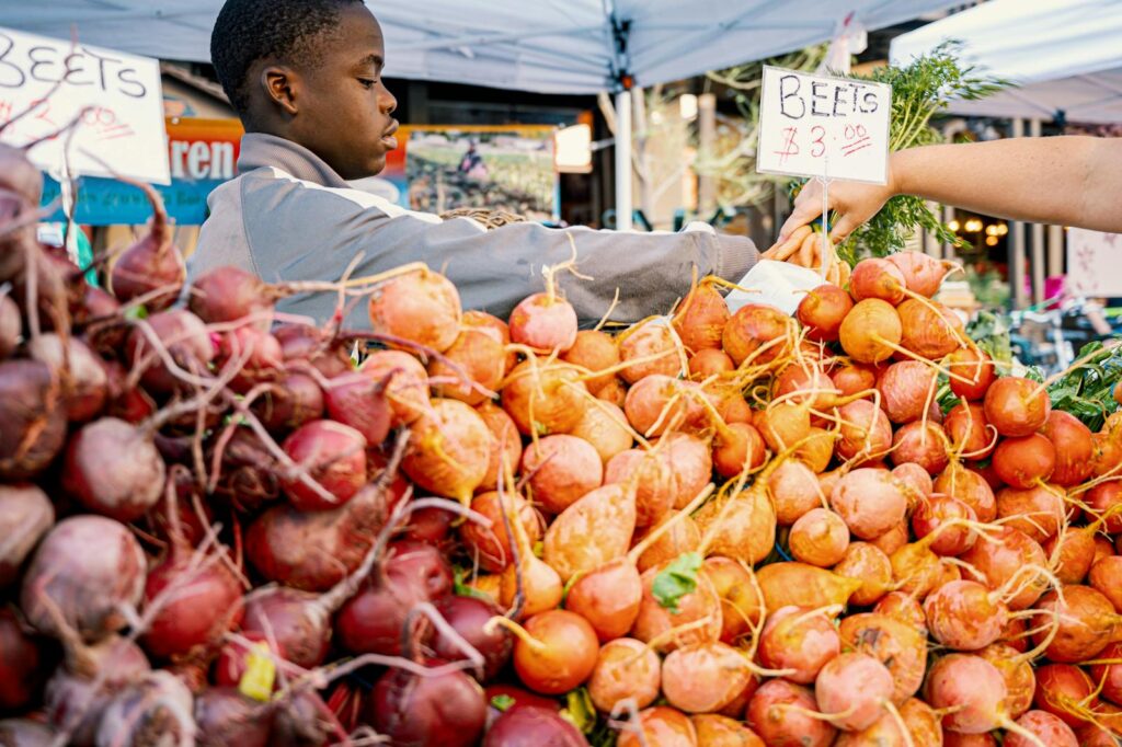 A vivid scene at a farmers market with fresh beets for sale, highlighting local produce and community commerce.