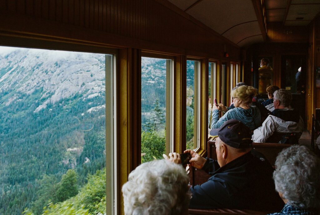 man in black jacket sitting on chair near window