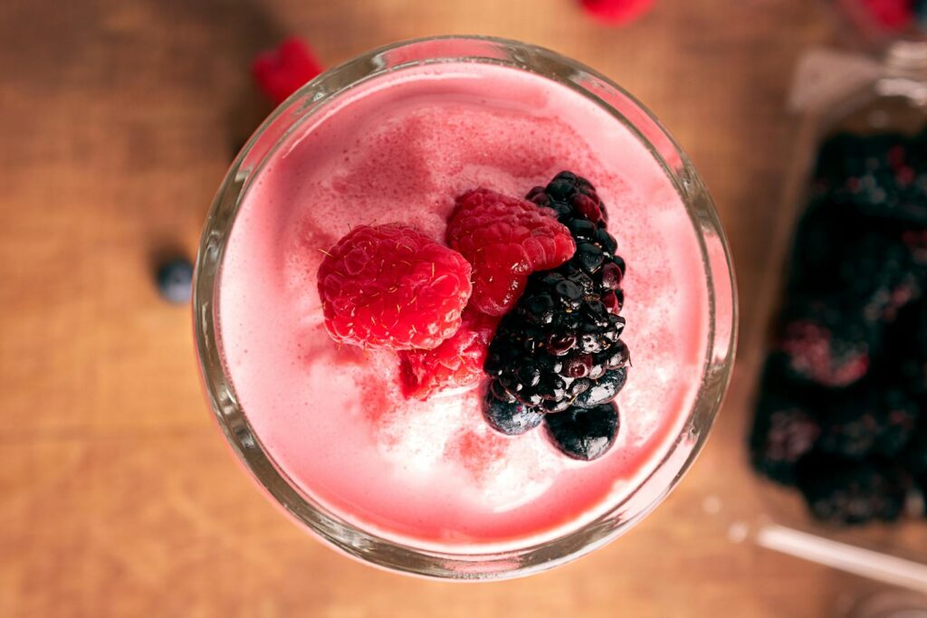 Top view of a refreshing mixed berry smoothie garnished with fresh raspberries and blackberries.