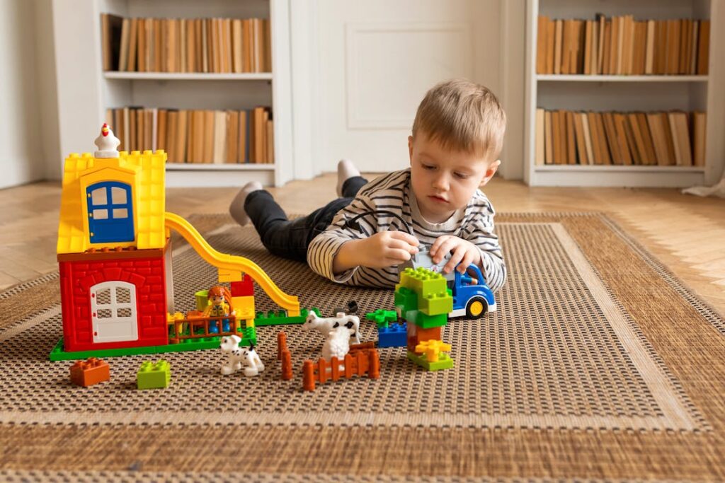 A lonely child sits quietly amid scattered expensive toys