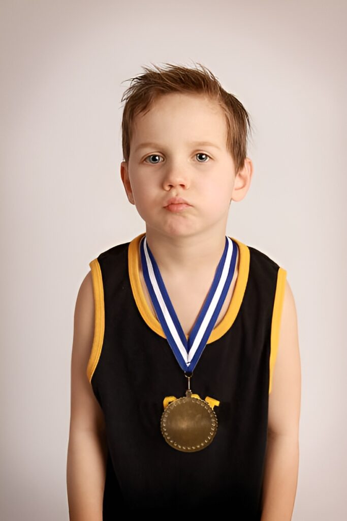 Child sits unnoticed beside scattered awards