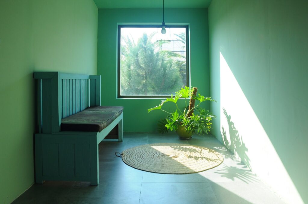 a green room with a bench and a window