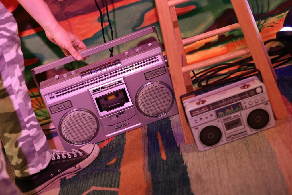 A person standing on top of a ladder next to a boombox