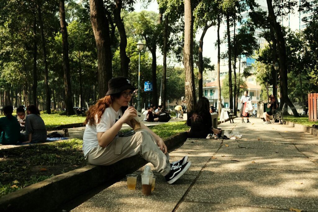 a woman sitting on a bench in a park