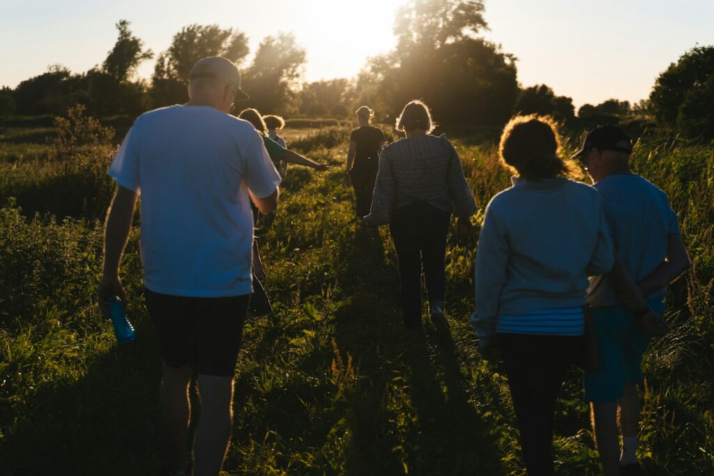 A group of people walking through a lush green field
