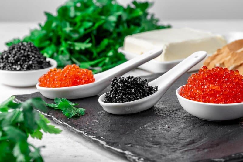 Food background with black and red caviar butter and parsley
