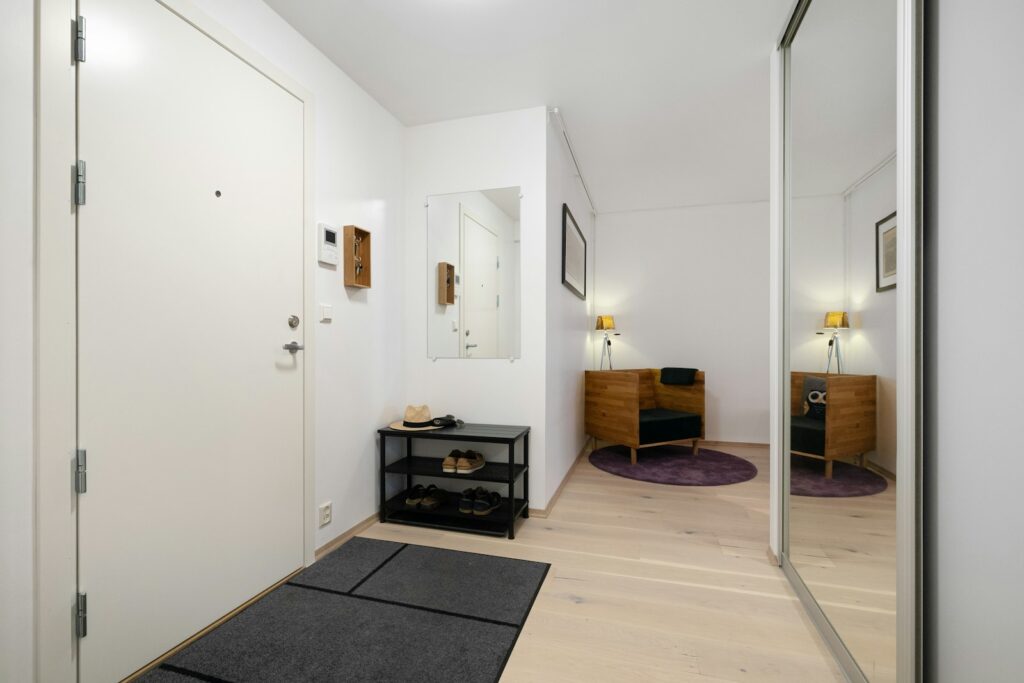 A hallway with a black rug and white walls