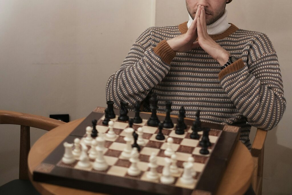 a man sitting at a table with a chess board