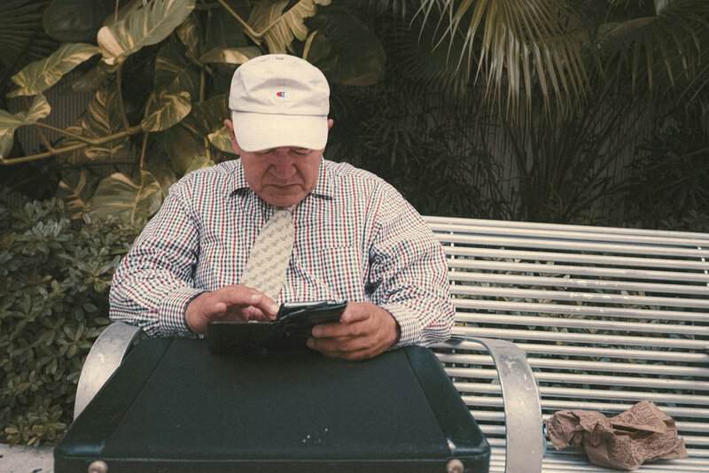 a man sitting on a bench looking at his cell phone