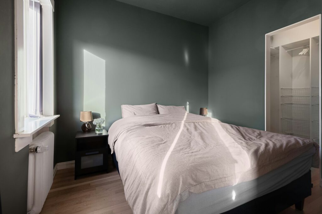 A bed sitting in a bedroom next to a window