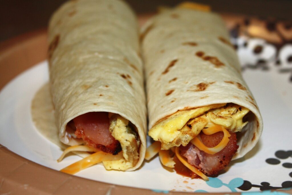 Two breakfast burritos on plate