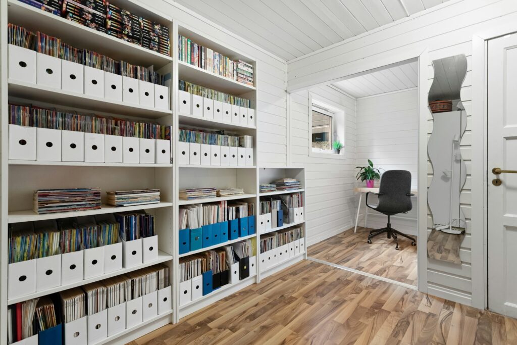 A room filled with lots of white shelves filled with books