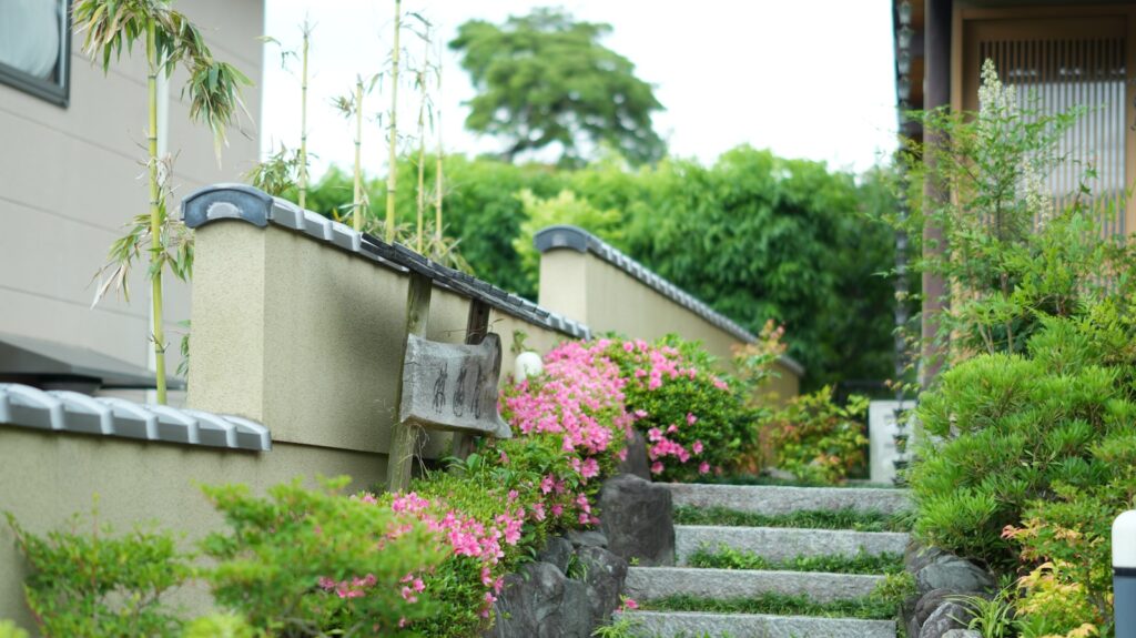 Staircase leads to a garden with pink flowers.